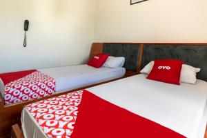 two beds in a room with red and white blankets at OYO Hotel Sunshine in São Bernardo do Campo