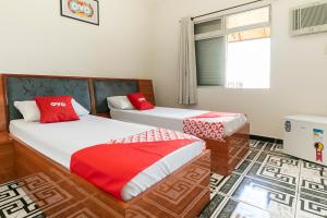 a bedroom with two beds with red and white sheets at OYO Hotel Sunshine in São Bernardo do Campo