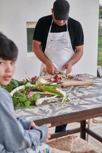 アリミニにあるMasseria Prosperiの男の子とテーブルの上で野菜を作る男