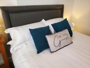 a bed with blue and white pillows on it at Ipswich Town Centre Apartment 5 in Ipswich