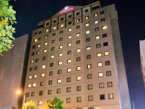 um edifício alto com um sinal em cima em Hotel Wing International Premium Tokyo Yotsuya em Tóquio