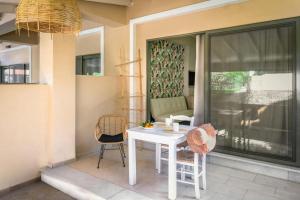 a white table and two chairs on a patio at Nissi Collection Rooms in Argassi