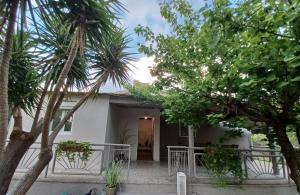 una casa con palmeras delante en Beach House for up to 9 people near Olympia en Katakolo