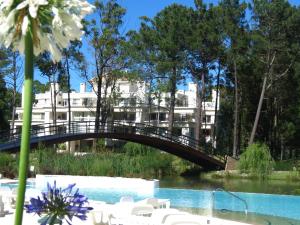 a bridge over a pool in front of a building at Green Park Propietarios in Punta del Este