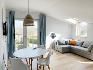 a living room with a white table and a couch at Apartamenty Pod Żaglami in Dziwnówek
