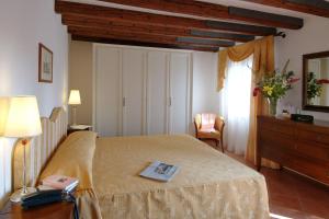 a bedroom with a bed with a book on it at Residence Corte Grimani in Venice