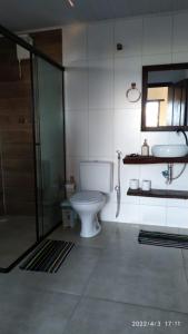 uma casa de banho com um WC, um chuveiro e um lavatório. em Chalé Suite do chá em Lavras Novas