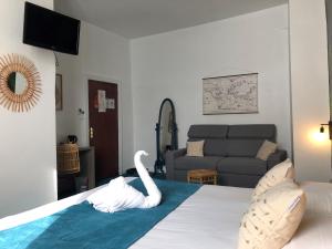 Un dormitorio con una cama con un cisne. en Hotel de France Citotel, en Rochefort