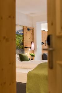 ein Schlafzimmer mit einem Bett und einem Wandgemälde in der Unterkunft Aktiv Panoramahotel Daniel in Sautens