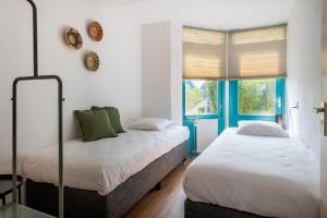 a bedroom with two beds and a window at Grimaud 179 - Kustpark Village Scaldia in Hoofdplaat
