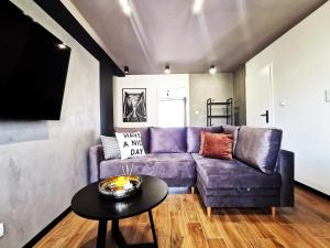a living room with a purple couch and a table at Gliniana Apartment ~ Self check-in 24h ~ Lift in Wrocław