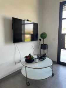 un soggiorno con tavolo e TV a schermo piatto di נוף לחרמון a Dafna