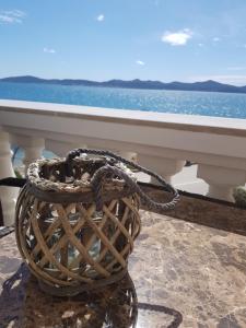 a basket on a balcony with a view of the ocean at Villa Punta in Zadar