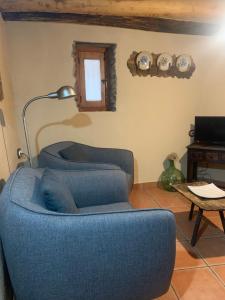 una sala de estar con 2 sillas azules y una lámpara en Caserío de Ovejuela, en Ovejuela