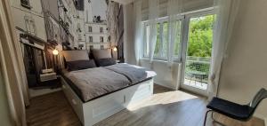 a bedroom with a bed and a large window at MoMa Homes Kecskemét in Kecskemét