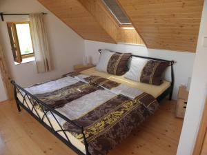 un letto in una stanza con soffitto in legno di charming house with beautiful landscape a Frýdštejn