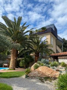 a house with palm trees in front of it at Apartments Villa BEAUTY PORTOROŽ in Portorož