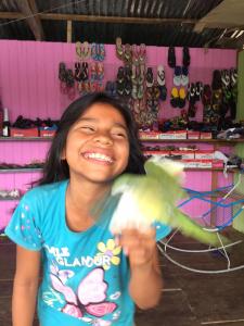 a young girl holding a bird in a store at Libertad Jungle Lodge in Yucuruche