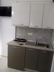 uma cozinha com um lavatório e uma bancada em petros house em Sarti