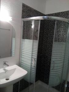 a bathroom with a glass shower and a sink at petros house in Sarti