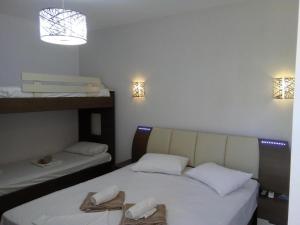 two beds in a room with twoperate beds with towels at petros house in Sarti