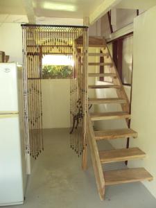 uma escada de madeira num quarto com um frigorífico em Riversideview House em Calibishie