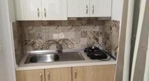 a kitchen with a sink and white cabinets at petros house in Sarti