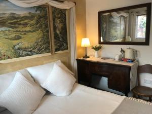 a bedroom with a bed and a painting on the wall at Cute self-contained guest room with ensuite and private decked porch in Glastonbury in Glastonbury