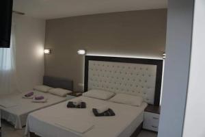 a bedroom with two beds with white sheets and towels at petros house in Sarti