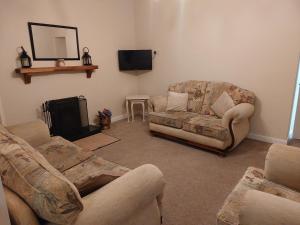 sala de estar con 2 sofás y chimenea en Seaview Cottage Dugort Achill Island, en Doogort