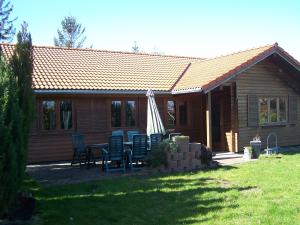 a house with a table and chairs in the yard at Blockhaus in Kägsdorf