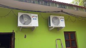 een groen gebouw met twee airconditioners erop bij Shrushthee Guest House in Vagator