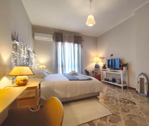 une chambre avec un lit, un bureau et une télévision dans l'établissement L'Attico - Stanza privata con bagno - Teatro Greco Siracusa, à Syracuse