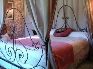 La Ferme Du Pressoir Guest House في Conteville: غرفة نوم عليها سرير ومخدة حمراء