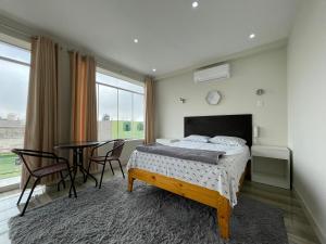 a bedroom with a bed and a table with chairs at Paris Senlis Hostel Plus in Chimbote +38 photos