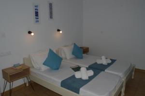 a bedroom with a bed with blue and white pillows at Pansion Katerina in Skiathos Town