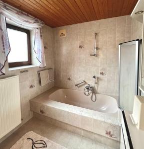 a bath tub in a bathroom with a window at Ferienwohnung Walker in Oberdrauburg