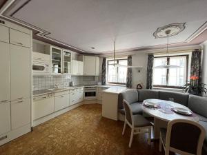 a kitchen with white cabinets and a table with chairs at Ferienwohnung Walker in Oberdrauburg +12 photos