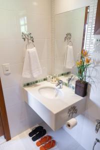 a bathroom with a sink and a mirror at Pousada Bela Aurora in Venda Nova do Imigrante