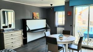 sala de estar con mesa y TV en Le Petit Bleu de Didonne 28m2 150 m de la plage avec balcon, en Saint-Georges-de-Didonne