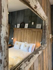 1 dormitorio con 1 cama en una pared de madera en The Pig and Sty, en Hereford