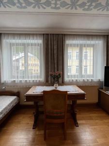 a room with a table and a bed and windows at Ferienwohnung Walker in Oberdrauburg