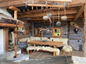 a wooden dining room with a wooden table and benches at Buccara Zwischenbachalm in Westendorf
