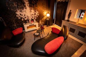 a living room with two chairs and a fireplace at Nuances d'Alcôves in Trévron