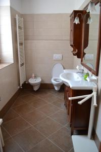 a bathroom with a toilet and a sink and a mirror at Casa Ledro in Ledro