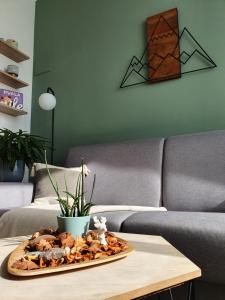 a tray of food on a table in front of a couch at Harmony - Your Cozy Retreat a Short Walk from the Center in Portorož
