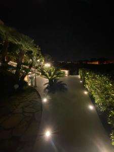 a walkway lit up at night with street lights at Villa Princi in Villa San Giovanni
