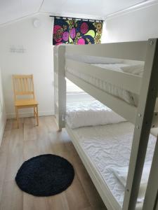 a bedroom with two bunk beds and a rug at Fjällägenhet boende Huså Byskola in Huså
