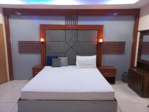 a bedroom with a large bed with white sheets at Hotel Executive One in Multan