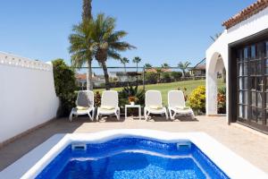 einen Pool mit Stühlen und ein Haus in der Unterkunft CASA GOLF beautiful views with private pool in San Miguel de Abona